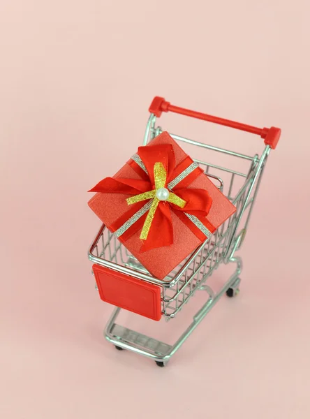 Caja de regalo con carritos de compras sobre fondo blanco —  Fotos de Stock