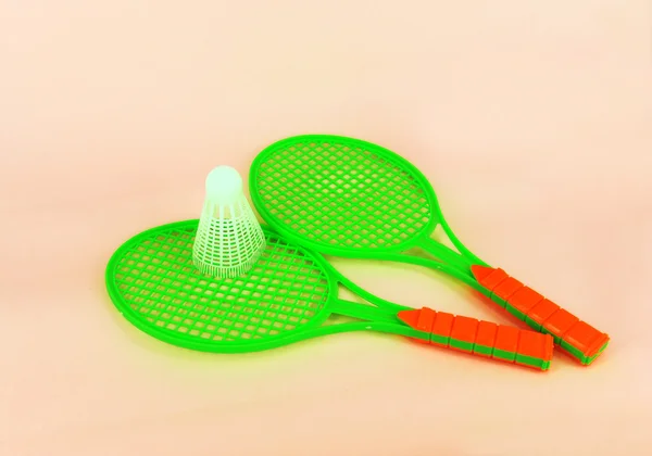 Two badminton rackets and shuttlecock isolated on pink background — Stock Photo, Image