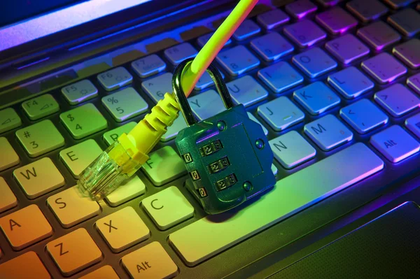 Lock och nätverks kabel med dator tangentbord bakgrund — Stockfoto