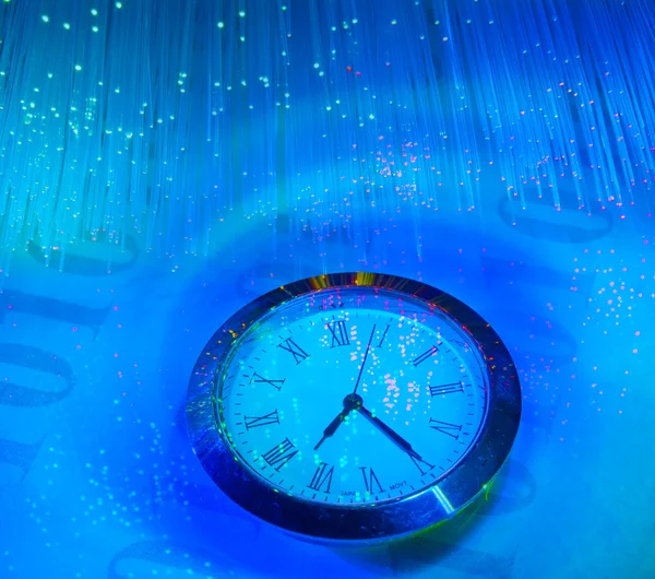 Часы на волоконно-оптическом фоне — стоковое фото