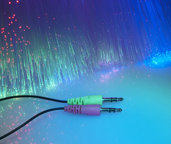 Headphone plug with fiber optical background — Stock Photo, Image