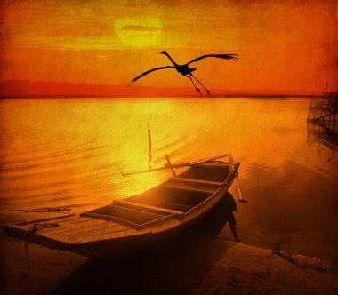 Bird and old fish-boat on sandy beach with beautiful sunset clipart