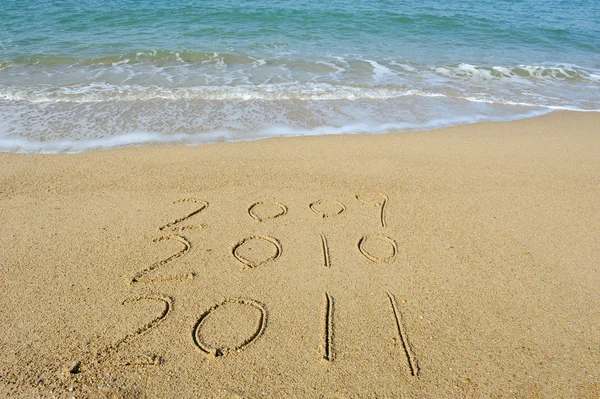 2011 année écrit à la main dans le sable sur une plage — Photo
