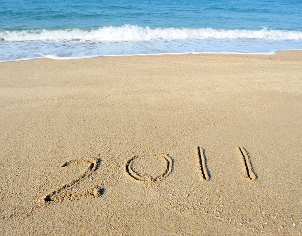 2011 ano escrito à mão na areia em uma praia — Fotografia de Stock