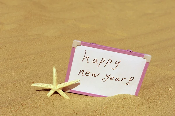 Happy new year message on the sand beach — Stock Photo, Image