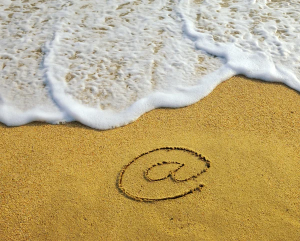 Рисунок электронного символа на пляже — стоковое фото