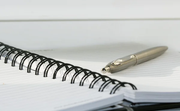 Ручка лежит на открытом ноутбуке — стоковое фото