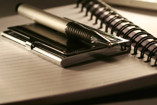 Penna liggande på öppnad anteckningsbok — Stockfoto