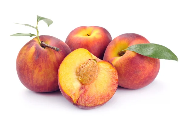 Pfirsich und eine Hälfte und Blätter — Stockfoto