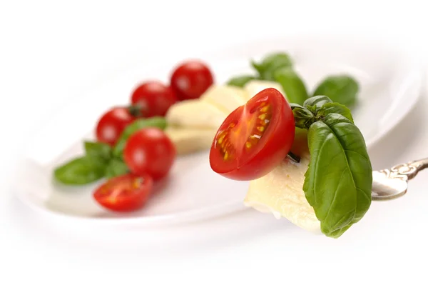 Mozzarella with tomato and basil on fork — Stock Photo, Image