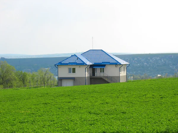 緑の牧草地の真ん中で孤独な生活の家 — ストック写真