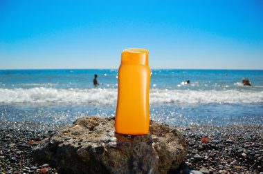 Tube with sun protection on beach of ocean clipart