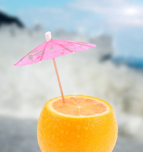 Лимон з парасолькою з розмитим морським фоном — стокове фото