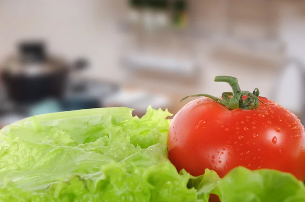 Groene salade en tomaat geïsoleerd met onscherpe achtergrond — Stockfoto