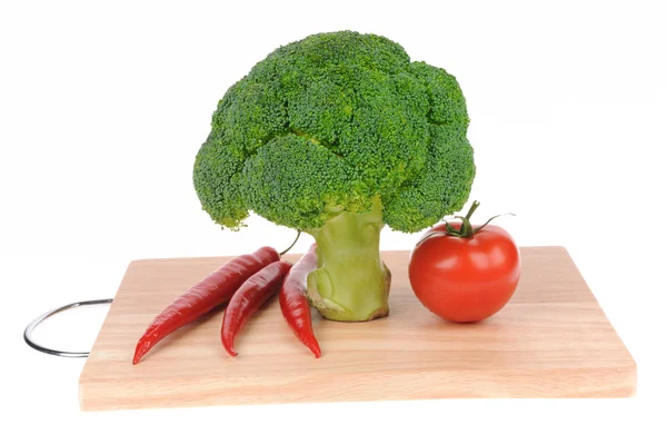 Brokkoli und Tomaten und Paprika auf Schneidebrett isoliert auf weiß — Stockfoto