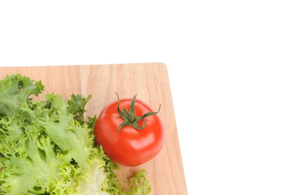 Salade verte et tomate sur planche à découper isolée sur blanc — Photo