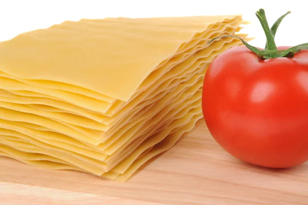 Lasaña pastacon tomate sobre tabla de cortar aislada sobre fondo blanco —  Fotos de Stock