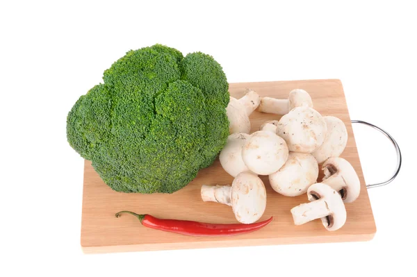 Mushrooms brocolli pepper on the cutting board isolated on the white backgr — Stock Photo, Image