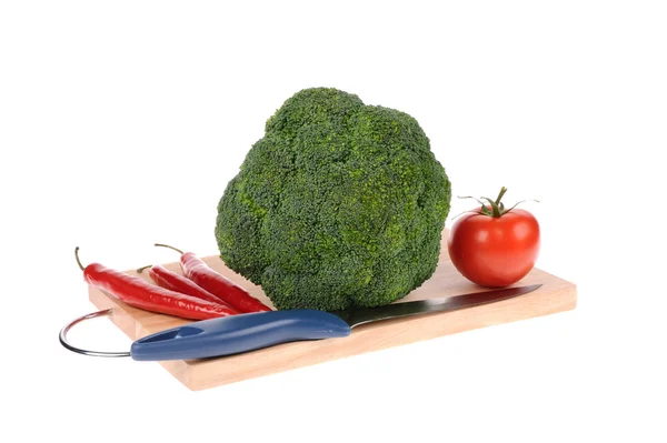 Broccoli tomatto pepper and knife on the cutting board — Stock Photo, Image