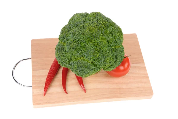 Brokuły i pomidory i papryka na cięcia pokładzie na białym tle — Zdjęcie stockowe