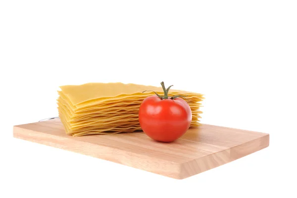 孤立在白色背景上的切割板上烤宽面条 pastawith 番茄 — 图库照片