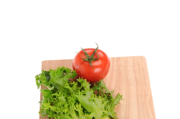 Salada e tomate sobre tábua de corte isolada sobre branco — Fotografia de Stock