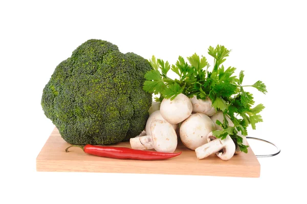 Mushrooms brocolli pepper on the cutting board isolated on the white backgr — Stock Photo, Image