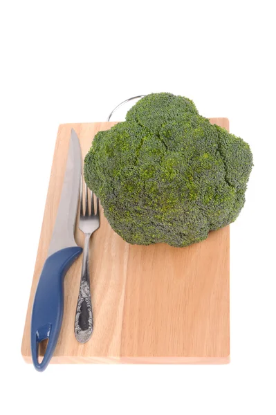 Broccoli with fork and knife on the cutting board isolated — Stock Photo, Image