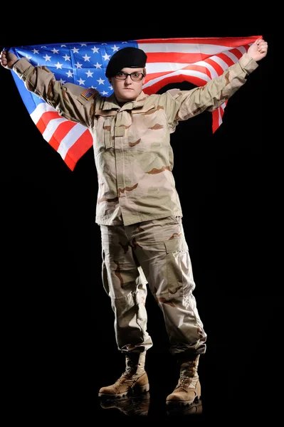 Женщина в военной форме с флагом в руках — стоковое фото