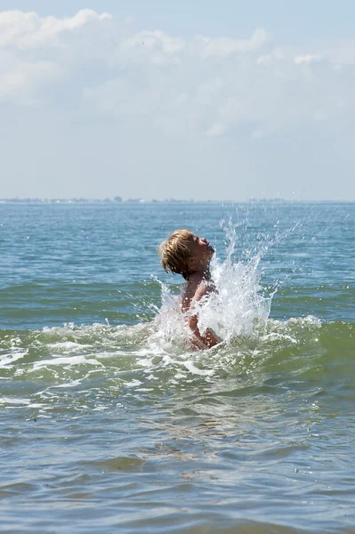 Мальчик играет в море — стоковое фото