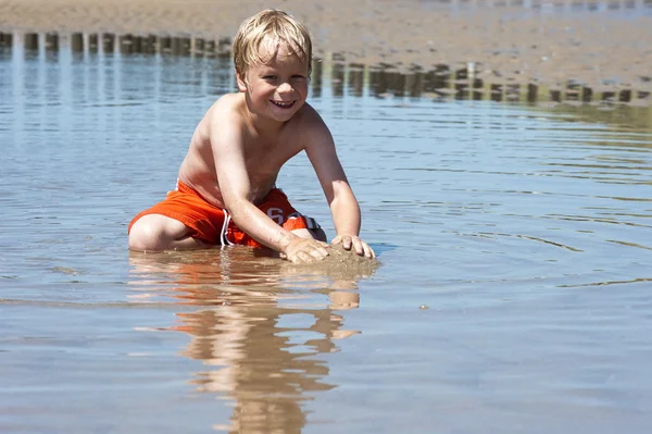 Мальчик играет с песком — стоковое фото