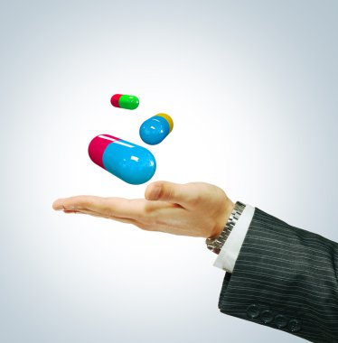 Pills on a businessman's hand clipart