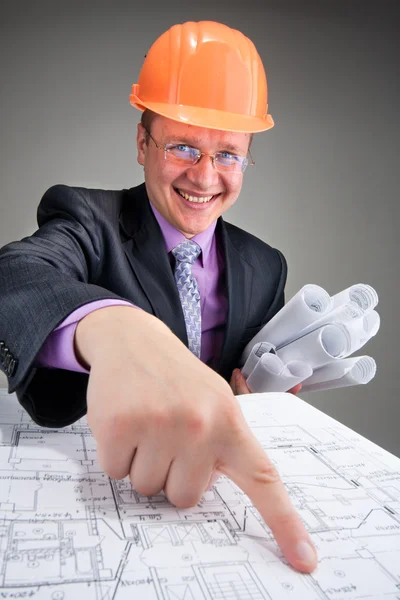 Happy contractor pointing to plans — Stock Photo, Image