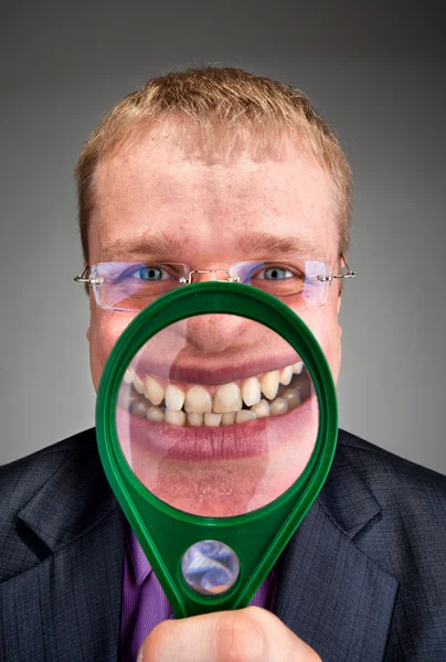 Glad affärsman leende genom förstoringsglas — Stockfoto