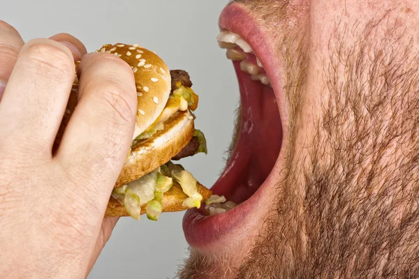 Uomo mangiare hamburger — Foto Stock