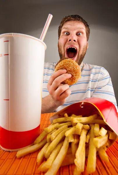 Ekspresyjny mężczyzna jedzenie fast food — Zdjęcie stockowe
