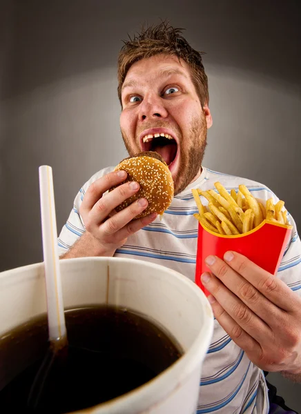 Homem expressivo comendo fast food — Fotografia de Stock