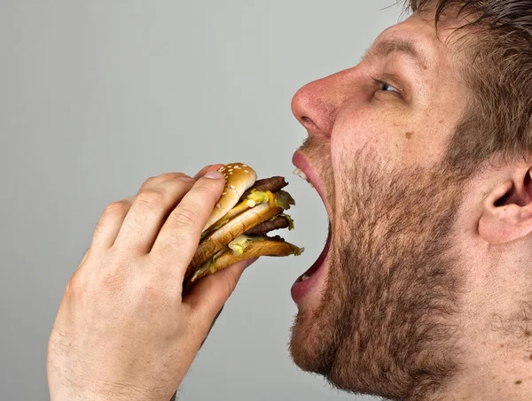 Uomo mangiare hamburger Fotografia Stock