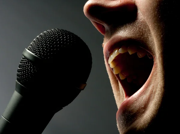 Человек поет под микрофон — стоковое фото