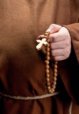 Hand holding wooden rosary