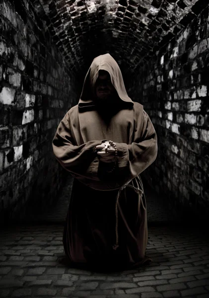 Orando monge no corredor escuro do templo — Fotografia de Stock