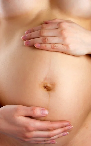Pregnant woman holding abdomen — Stock Photo, Image
