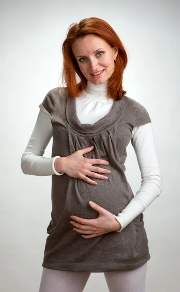 Heureuse femme enceinte tenant l'abdomen — Photo
