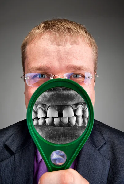 Woedend zakenman glimlachen door vergrootglas — Stockfoto