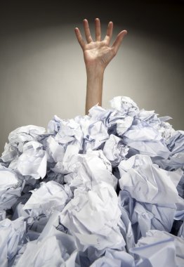 Hand reaches out from heap of papers clipart