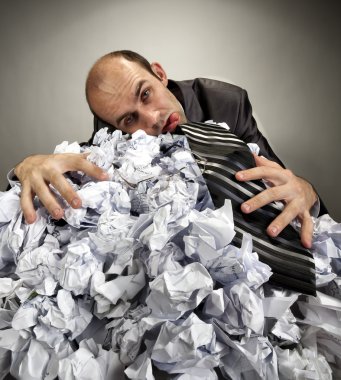 Exhausted depressive businessman laying on crumpled papers clipart
