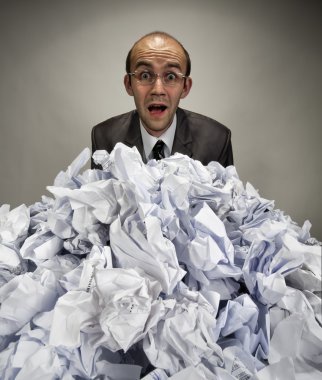 Surprised businessman reaches out from crumpled papers clipart
