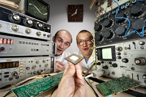 Dos científicos nerd divertido mirando procesador de computadoras moderno — Foto de Stock