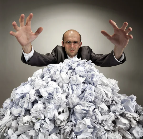 Ernstige zakenman reikt van verfrommeld papier — Stockfoto
