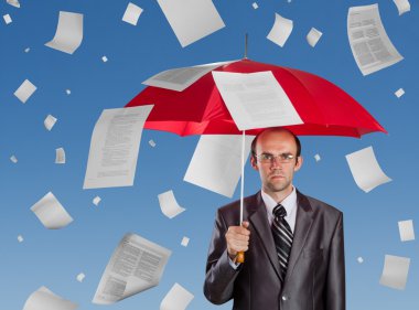 Businessman with red umbrella under falling documents clipart